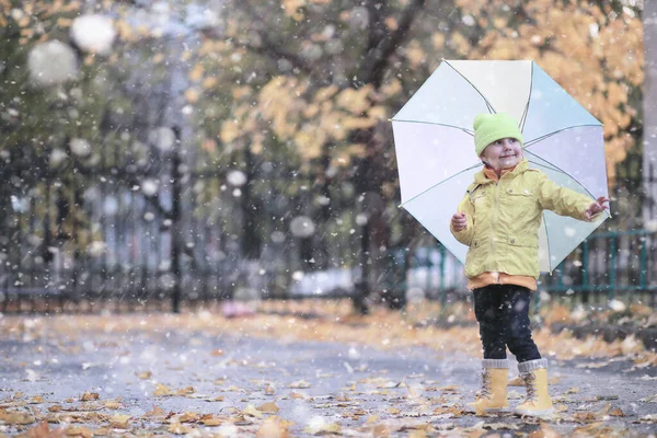 Dzieci chodzą w parku pierwszy śnieg — Zdjęcie stockowe