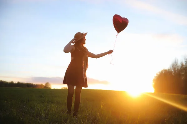 Una ragazza con un cappello mentre passeggia nel parco. Una ragazza con un cesto a piedi — Foto Stock