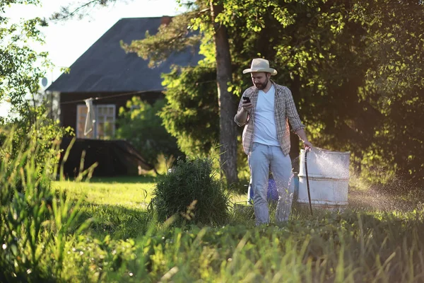 Homem agricultor regando uma horta — Fotografia de Stock