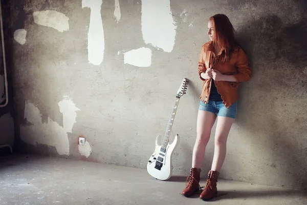 Νεαρή κοκκινομάλλα κοπέλα με μια ηλεκτρική κιθάρα. Gir μουσικός βράχου — Φωτογραφία Αρχείου