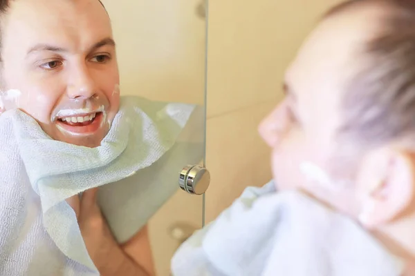 A man shaves in the bathroom in the morning — Stock Photo, Image