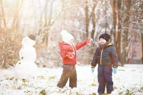 冬の公園で遊ぶ暖かい服のかわいい子供たち — ストック写真