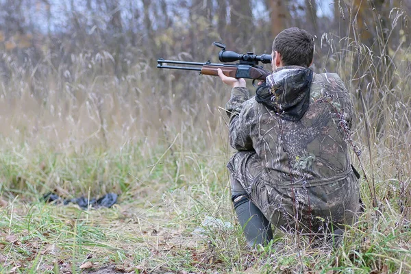 Hombre en camuflaje y con armas en un cinturón forestal en un hun de primavera — Foto de Stock