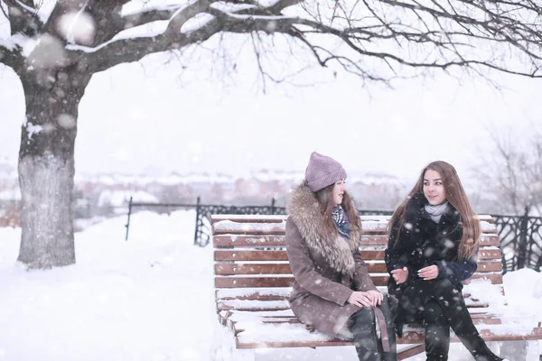 Flicka i en vinterpark i snöfall — Stockfoto