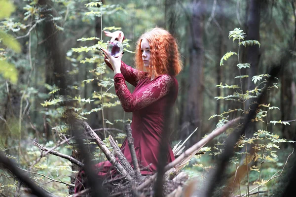 Die rothaarige Hexe hält ein Ritual mit einer Kristallkugel — Stockfoto