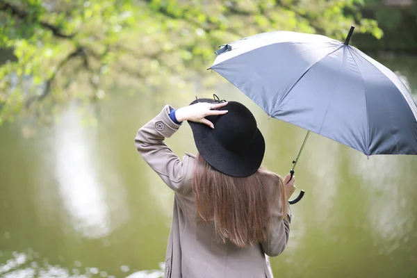 Fiatal lány, egy kabát, egy tavaszi parkban — Stock Fotó