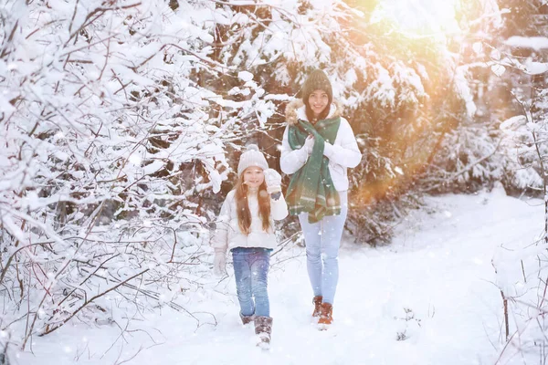 Young family for a walk. Mom and daughter are walking in a winte — Stock Photo, Image