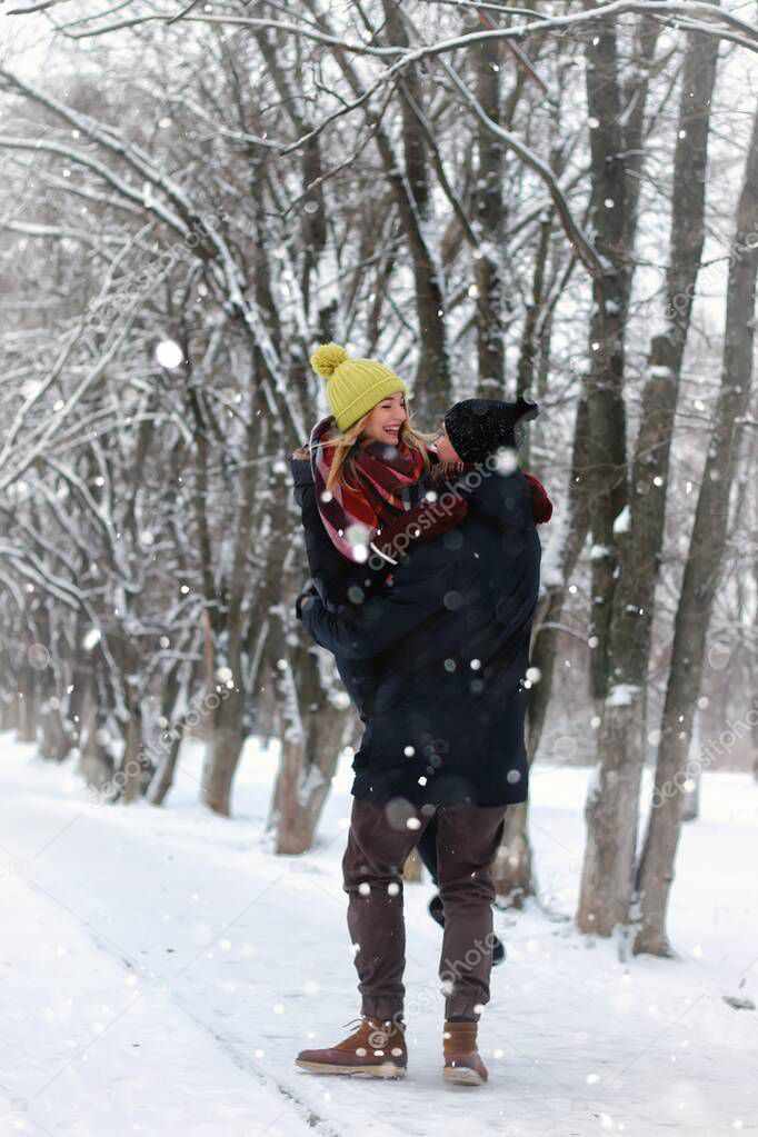 young lovers waling in snowy winter park