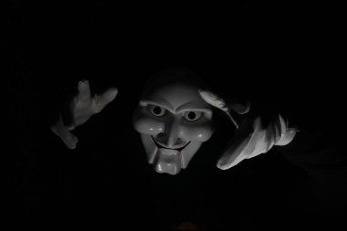 Siyah arka planda beyaz, korkunç bir maske..