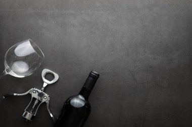 Şarap kadehi ve siyah şarap şişesi. Ceviz peyniri ve domates.