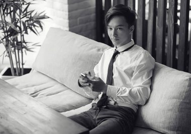 Genç Asyalı işadamı bir kafede bir ortak için bekliyor. Bu