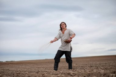 Genç bir köylü tahıl alanıyla sows