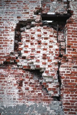 Kırık ve acı izleri olan eski kırmızı tuğla duvar.