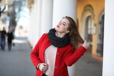 Şehirde kırmızı paltolu bir yolda güzel kız