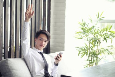 Genç Asyalı işadamı bir kafede bir ortak için bekliyor. Bu