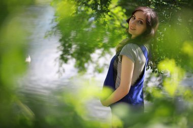 Hamile bir kadın parkta yürüyor.