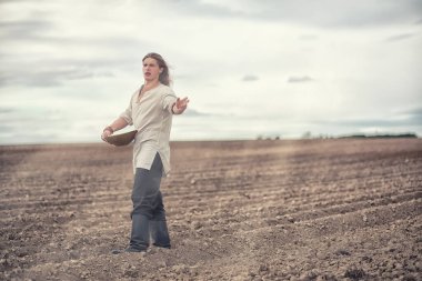 Genç bir köylü tahıl alanıyla sows