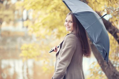 Sonbahar yağmurlu hava ve bir şemsiye ile genç bir adam