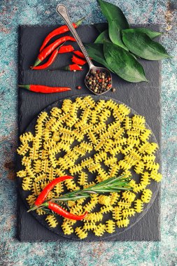 Taş zeminde pişmemiş makarna. Baharat ve baharatlarla