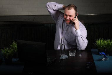 Masada oturan ve dizüstü bilgisayarda çalışan adam