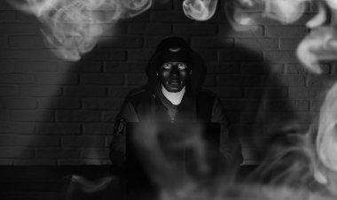 Siyah maske ve hood masada hacker