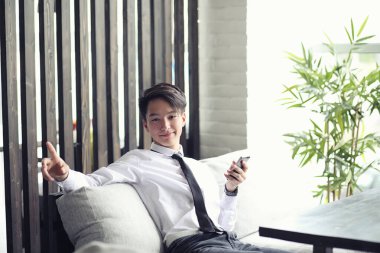 Genç Asyalı işadamı bir kafede bir ortak için bekliyor. Bu