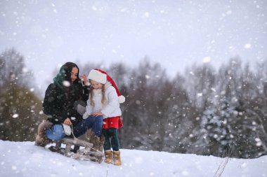 Bir kış masal, genç bir anne ve kızı bir kızak sürmek