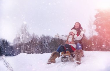 Bir kış masal, genç bir anne ve kızı bir kızak sürmek
