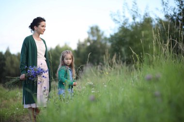 Anne ve kızı yolda yürüyor.