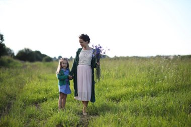 Anne ve kızı yolda yürüyor.