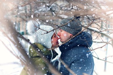 Genç bir çift kış parkında yürüyor.