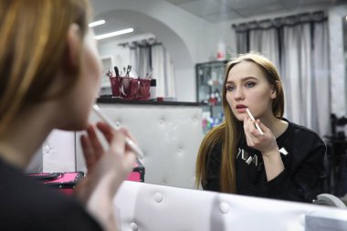 Genç bir kız bir güzellik salonu makyaj yapar. Kız açık o