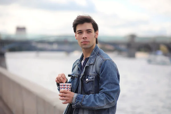 A young man walks in the park at lunch time. A man is on a walk