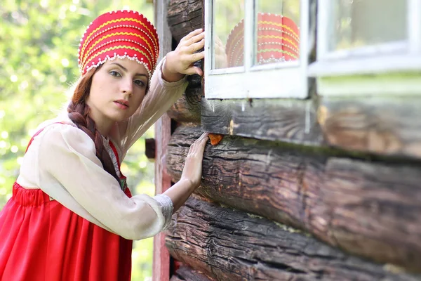 Слов'янська жінка в традиційному одязі дерев'яні стіни — стокове фото