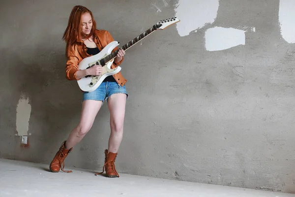 Νεαρή κοκκινομάλλα κοπέλα με μια ηλεκτρική κιθάρα. Gir μουσικός βράχου — Φωτογραφία Αρχείου