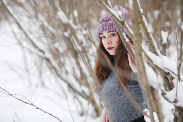 Seorang gadis muda di taman musim dingin berjalan-jalan. Liburan Natal di t — Stok Foto