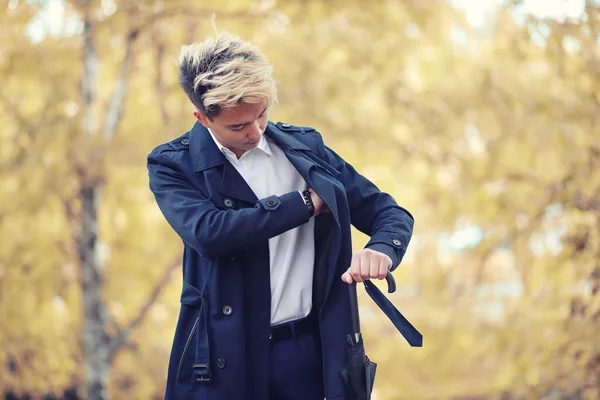 Autunno tempo piovoso e un giovane uomo con un ombrello — Foto Stock