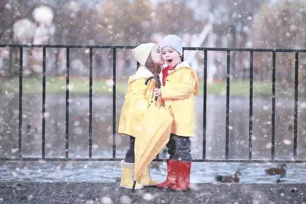 Les enfants marchent dans le parc première neige — Photo