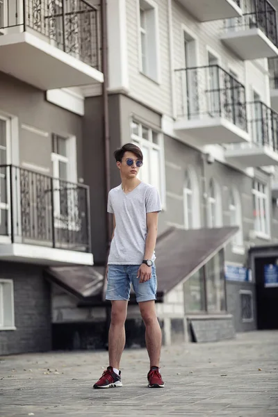 アジア系の若い男は身に着けているサングラス アウトドア — ストック写真