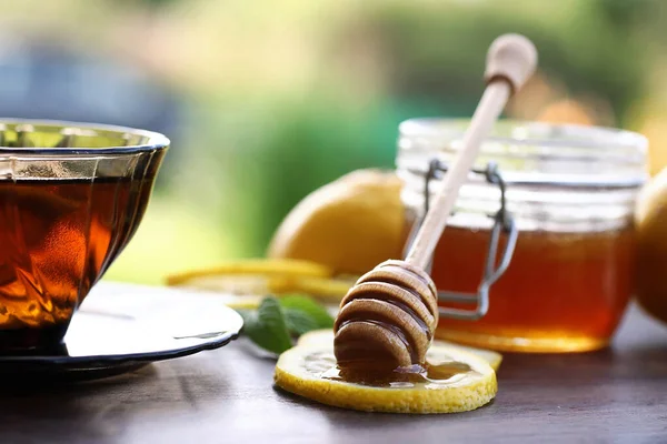 Miel fresca con una taza de té negro — Foto de Stock