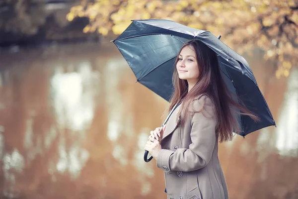 Outono tempo chuvoso e um jovem com um guarda-chuva — Fotografia de Stock