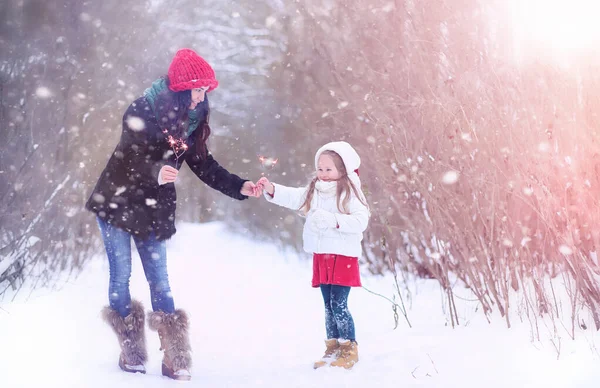 Зимова казка, молода мама і її дочка катаються на санях — стокове фото