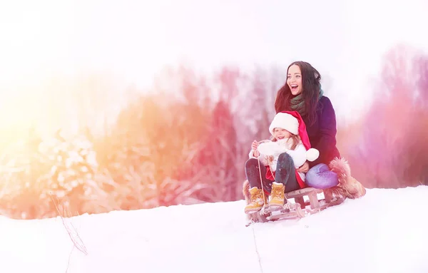一个冬天的童话故事, 一个年轻的母亲和她的女儿骑雪橇 — 图库照片