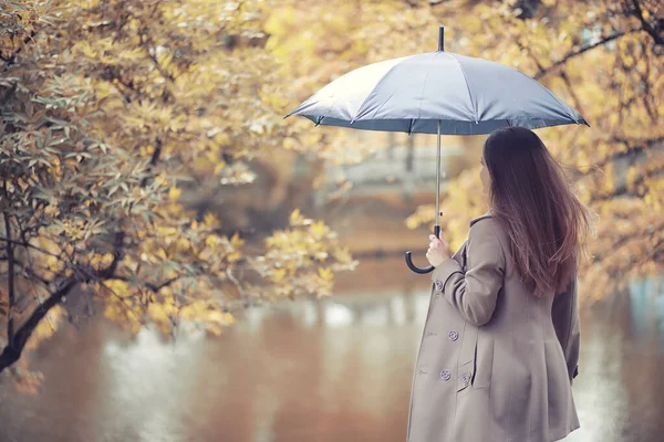 Autunno tempo piovoso e un giovane uomo con un ombrello — Foto Stock