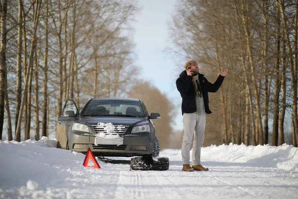 A man near a broken car on a winter day — Stock Photo, Image