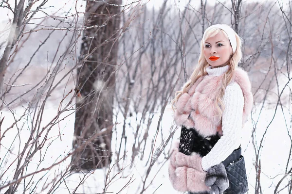 Nieve día rubia chica en un paseo en un parque de invierno — Foto de Stock