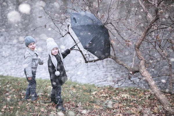 Crianças caminham no parque primeira neve — Fotografia de Stock