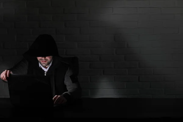 Hacker bertopeng hitam dan hood di meja — Stok Foto