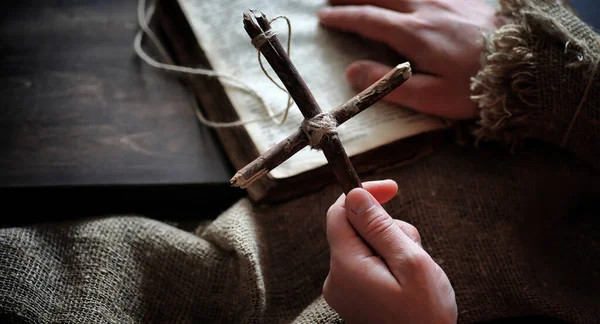 Livro velho religioso em uma mesa de madeira. Uma cruz religiosa amarrado sagacidade — Fotografia de Stock