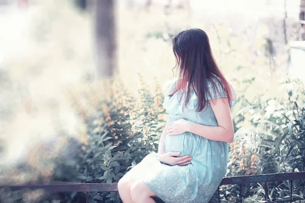 Chica embarazada en un vestido en la naturaleza — Foto de Stock